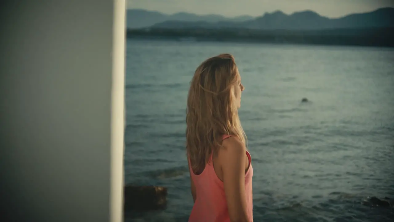 Woman standing in front of the sea and attending around