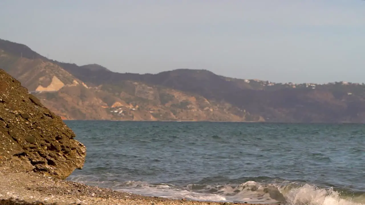 Slow motion low angle ocean view with waves and land in distance