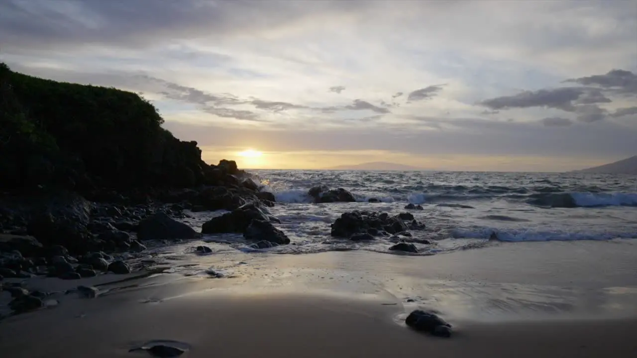 Lowering slow motion scene of a rocky beach at sunset in Maui Hawaii