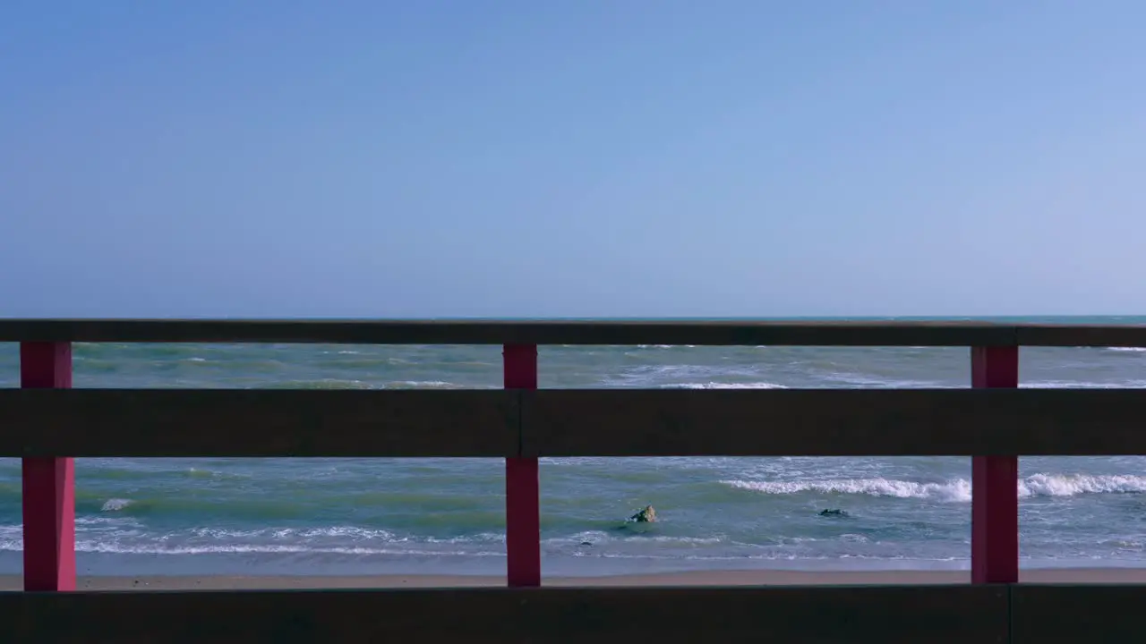 Ocean waves in slow motion behind the wooden deck