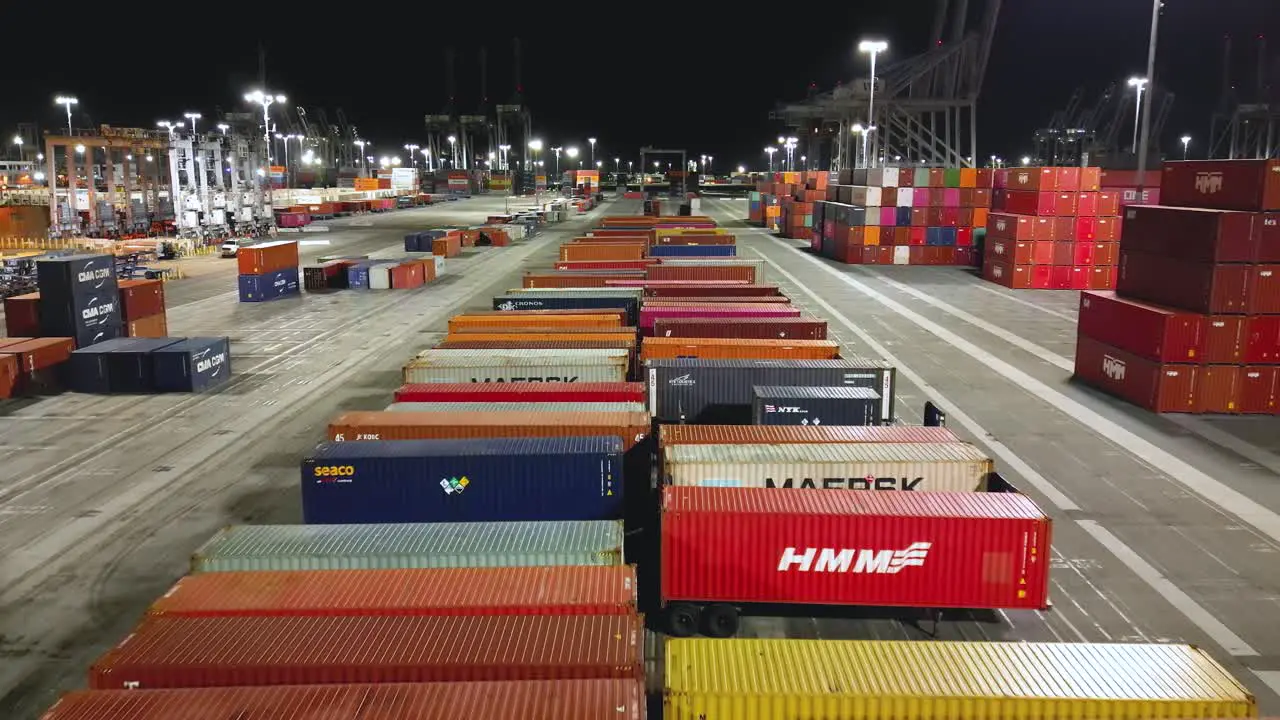 shipyard in Long Beach at night in this drone aerial view showcasing towering cranes and rows of cargo containers at night