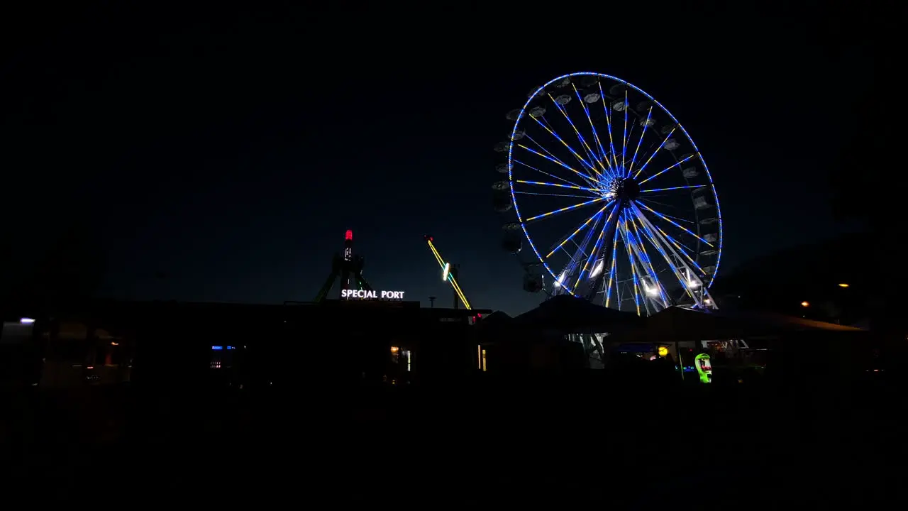 Colorful Ferris Wheel Against The Night Sky At The Amusement Park In Poland wide shot