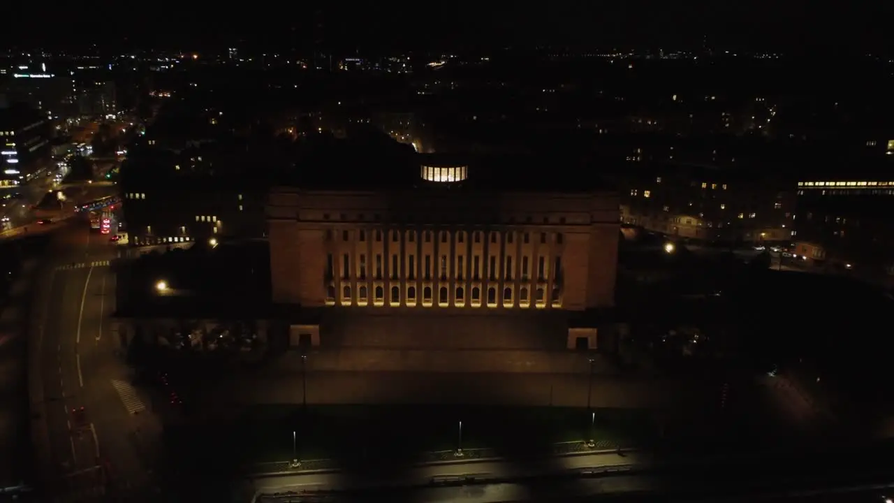 Black night aerial pulls back from Parliament House building Helsinki