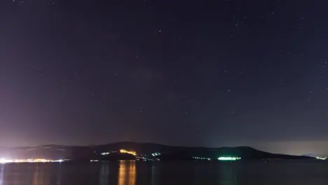 Beautiful sea time lapse during night with stars and city lights Turkey Didim