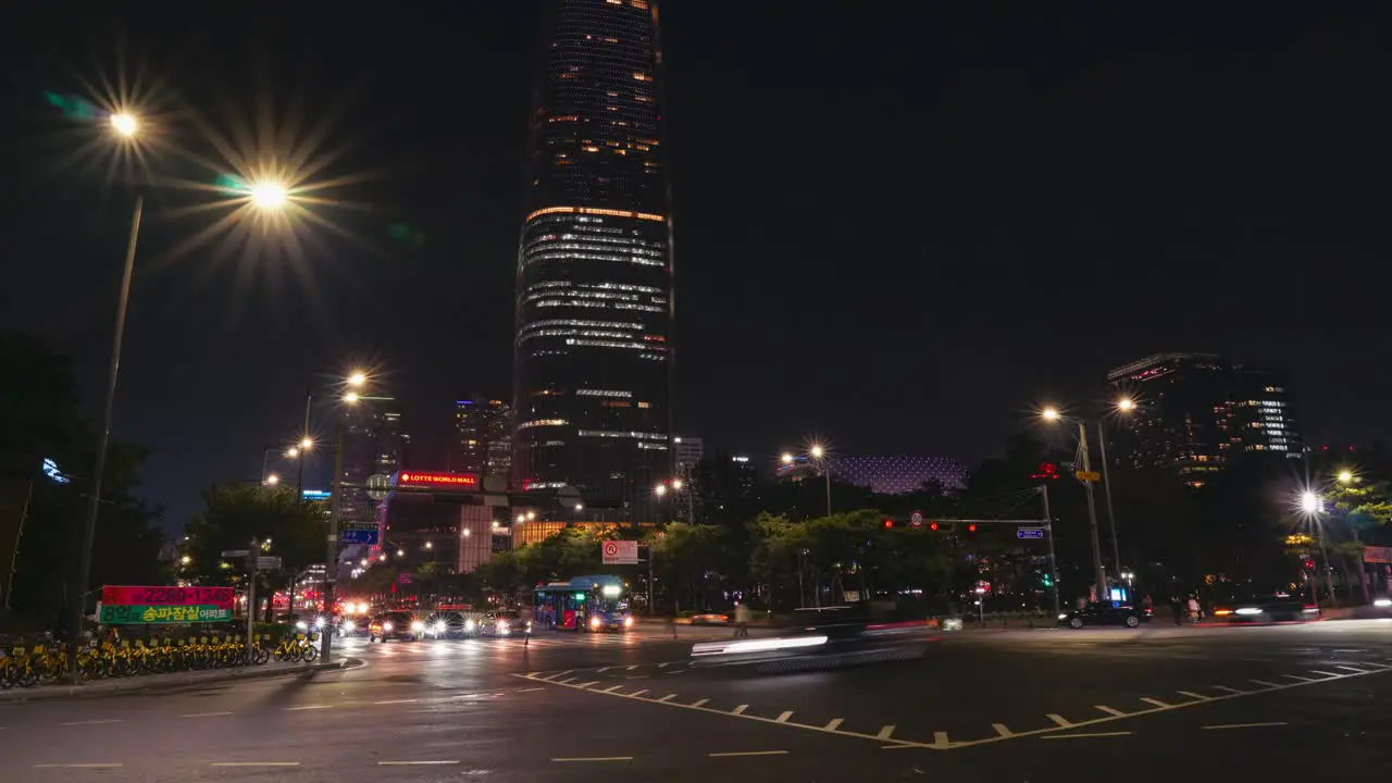 Night traffic on multilane crossroad near Lotte World Tower Mall in Seoul timelapse with light trails