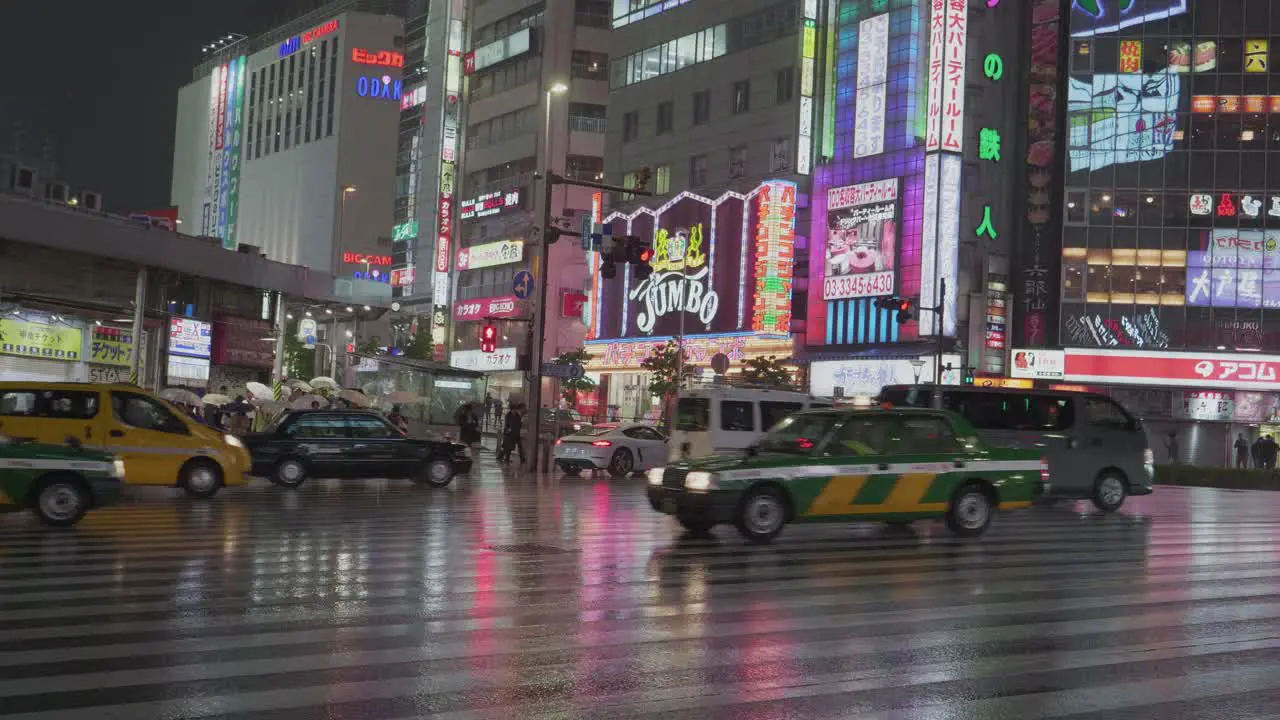 a huge traffic intersection in Shinjuku District Tokyo Japan at a rainy night