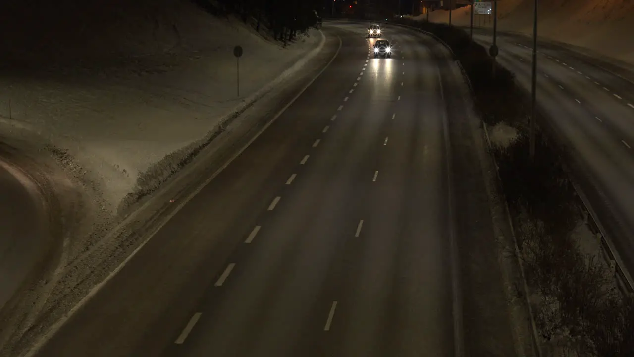 Overview of car movement on a two-lane road in the middle of the city at night time