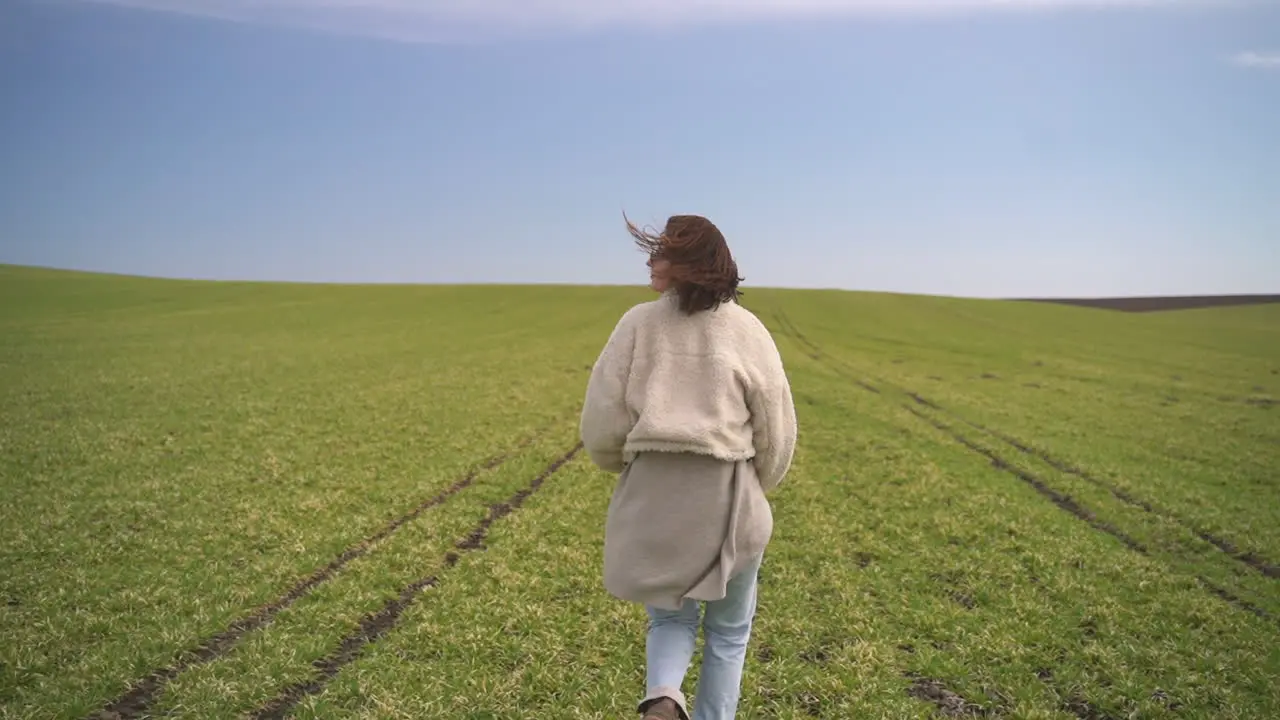 A Young Beautiful Brunette Girl Runs Through A Green Meadow