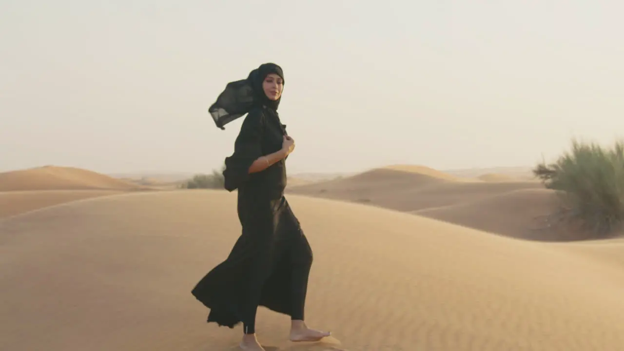 Retrato De Una Hermosa Mujer Musulmana Con Hiyab Caminando En Un Desierto Ventoso Y Mirando La Cámara 1