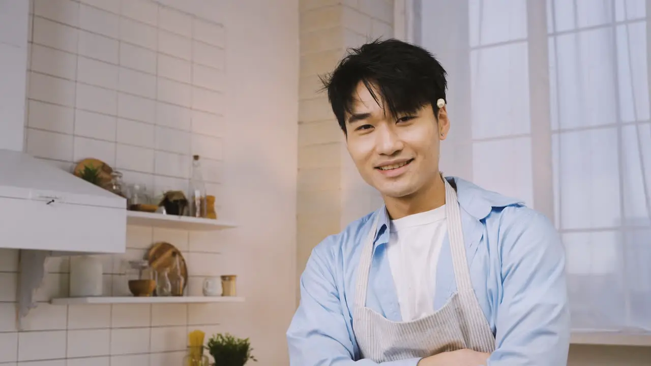 Hombre Japonés Cortando Ingredientes En La Cocina Luego Mira A La Cámara Y Sonríe 3