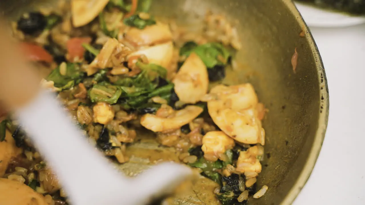 Close Up View Of Japanese Food In The Pan While The Cook Moves It With A Slotted Spatula