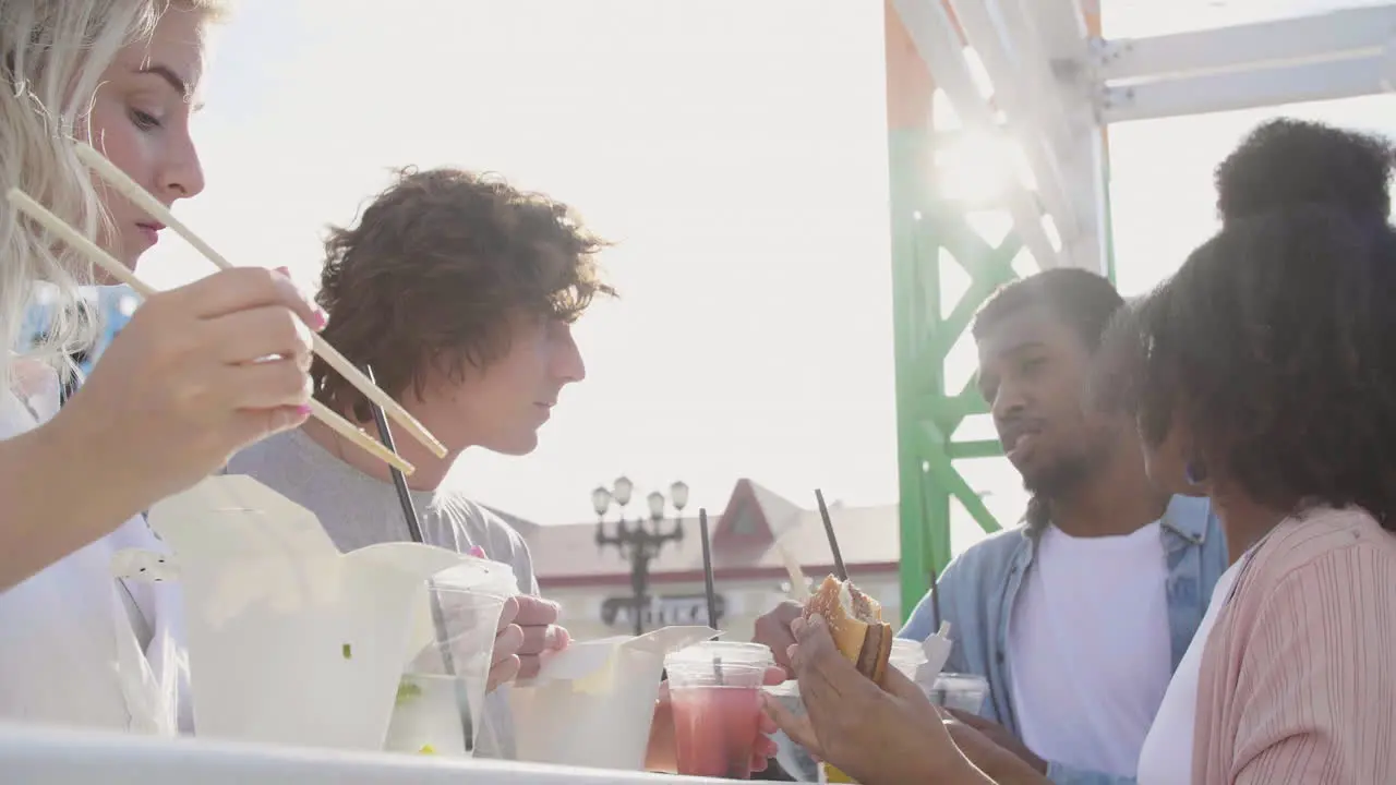 Group Of Friends Eating Street Food In The City While Chatting And Spending Time Together