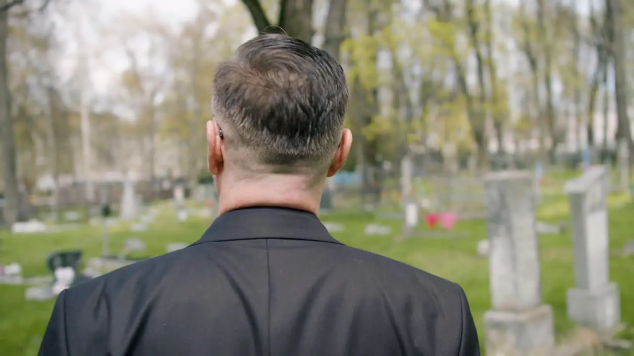 Vista Trasera De Un Hombre Con Traje Negro Caminando En Un Cementerio