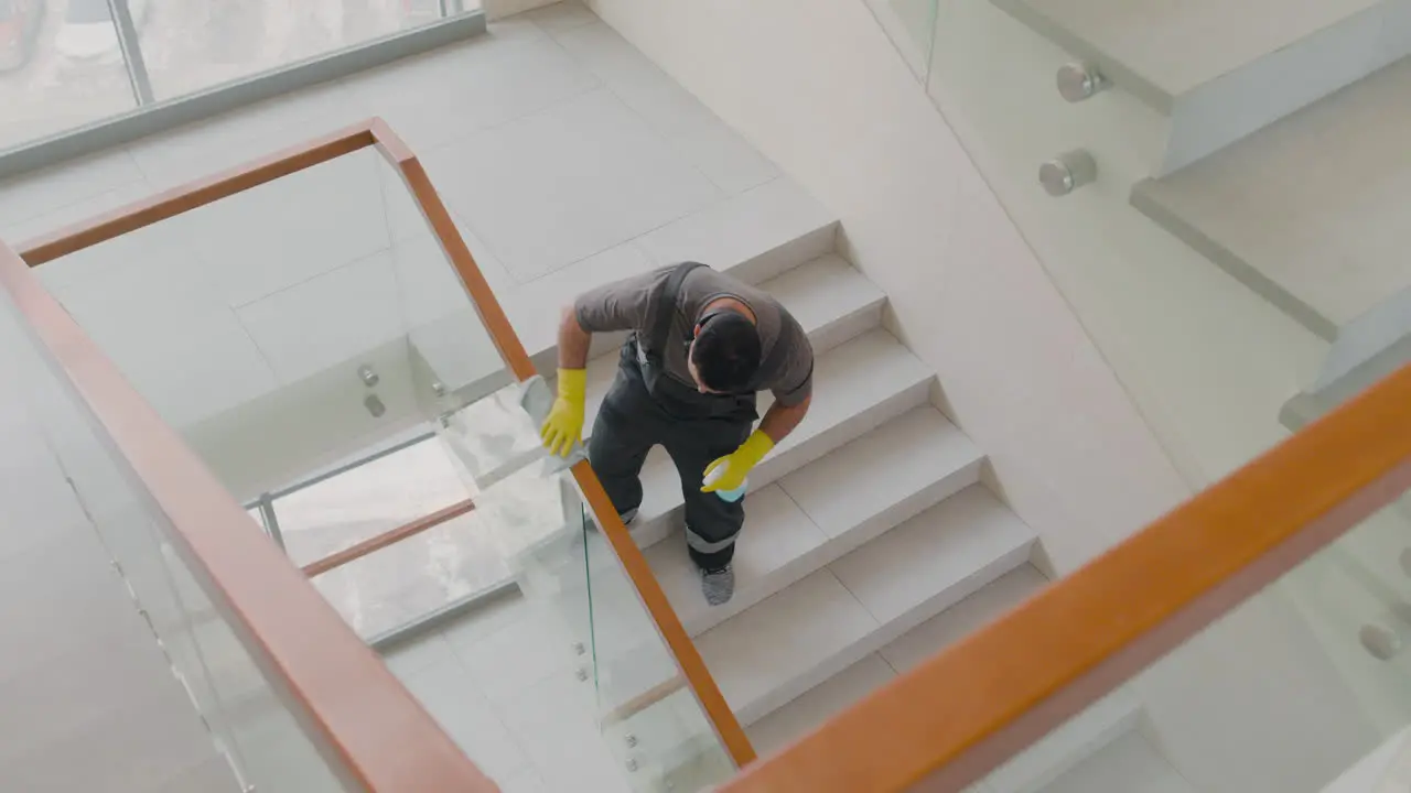 Blick Von Oben Auf Einen Arabischen Putzmann Mit Handschuhen Der Treppengeländer Und Kristalle In Einem Bürogebäude Reinigt