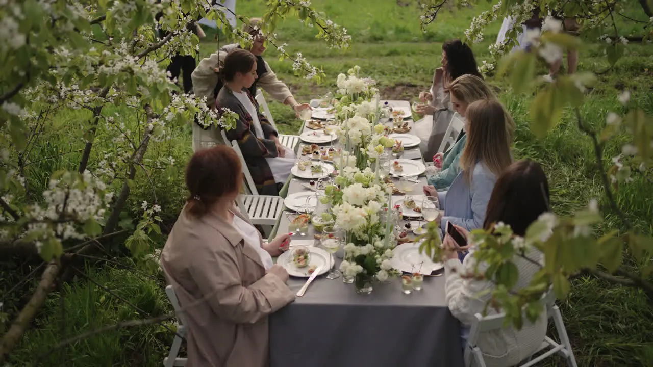 An Frühlingstagen Ruhen Sich Die Menschen Aus Und Essen Im Blühenden Garten Zu Mittag Während Sie Unter Blühenden Bäumen Sitzen