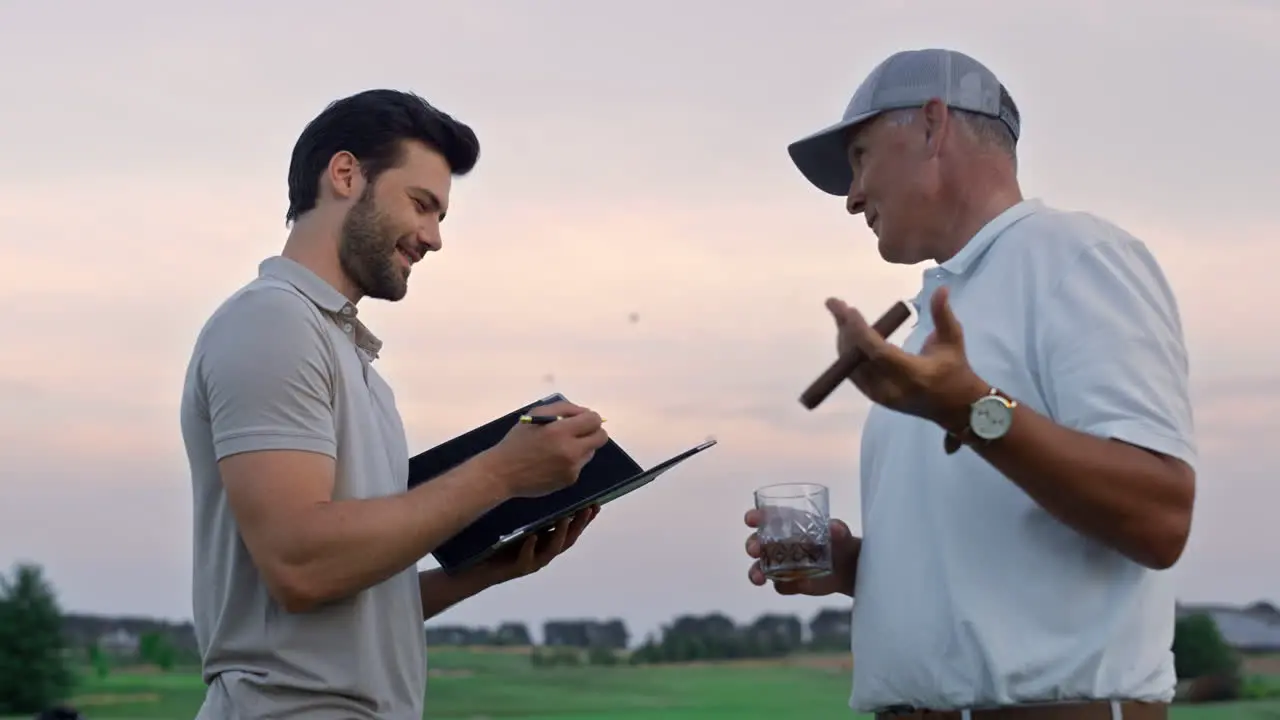 Zwei Männer Unterhalten Sich Draußen über Den Golfplatz Golfer Analysieren Spielergebnis Auf Dem Feld Bei Sonnenuntergang