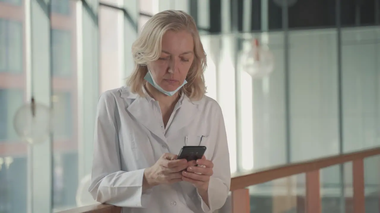 A Blonde Middle Aged Female Doctor Sends A Mobile Phone Text Message