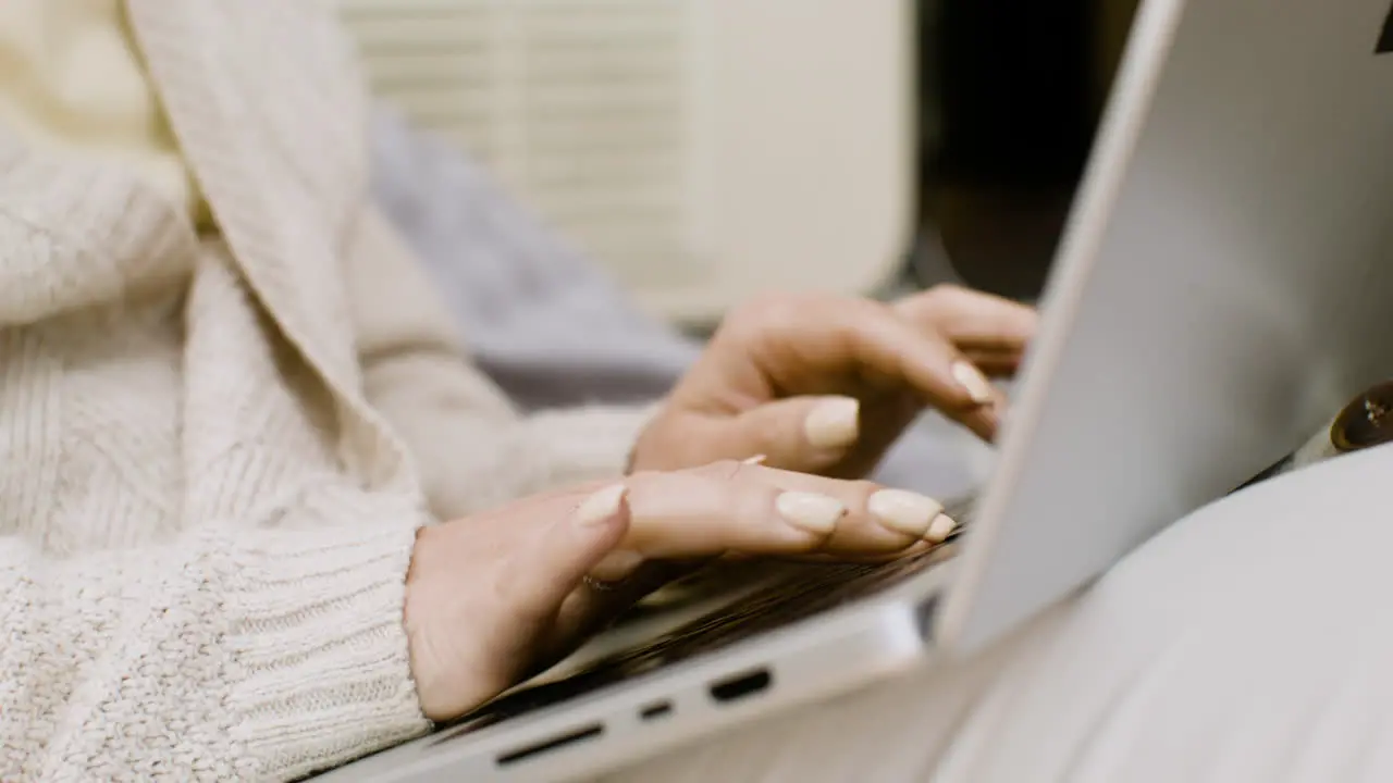 Close up of an unrecognizable woman working on laptop computer outdoors