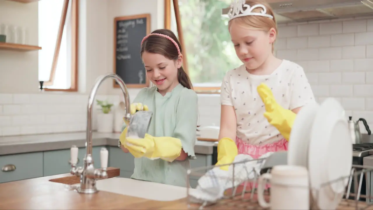 Children learning and cleaning dishes in kitchen