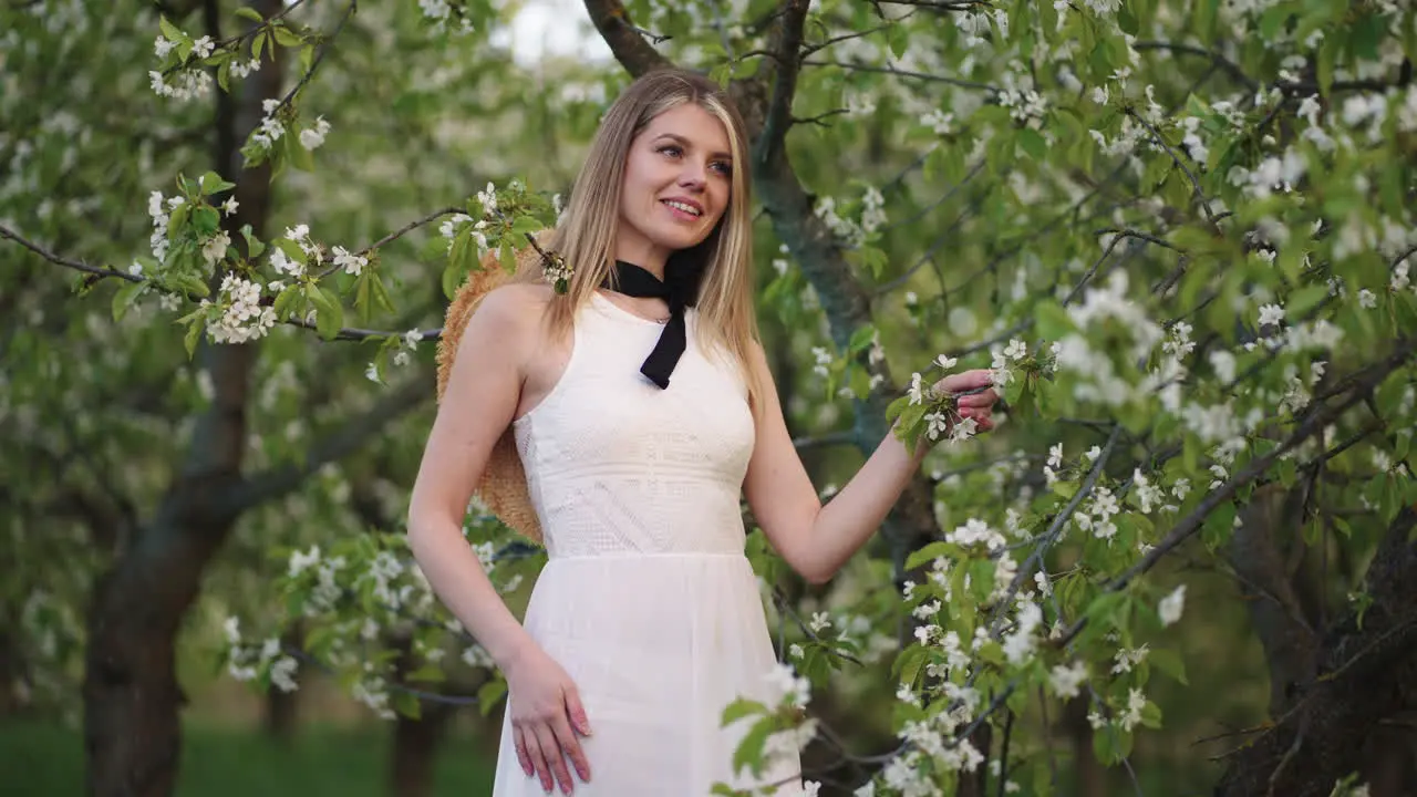 portrait of charming young woman in blooming garden attractive lady is standing under fruit tree