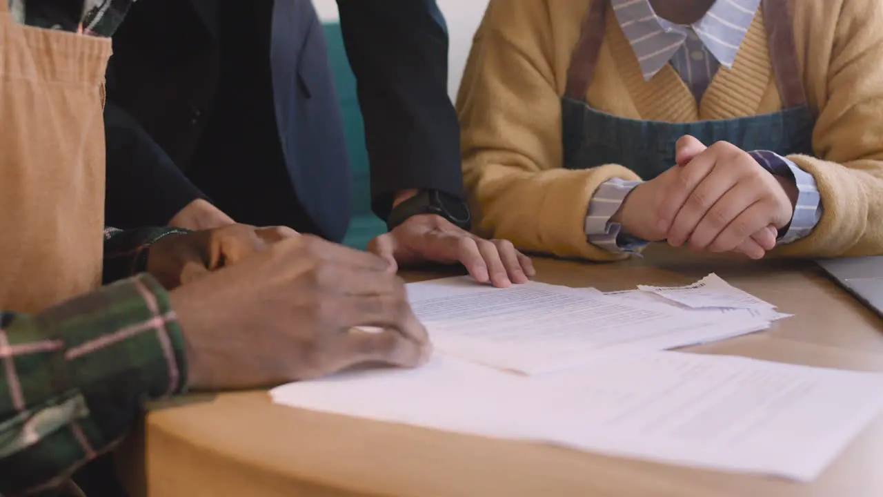 Three Unrecognizable Small Business Owners Doing Accounting In Their Coffee Shop