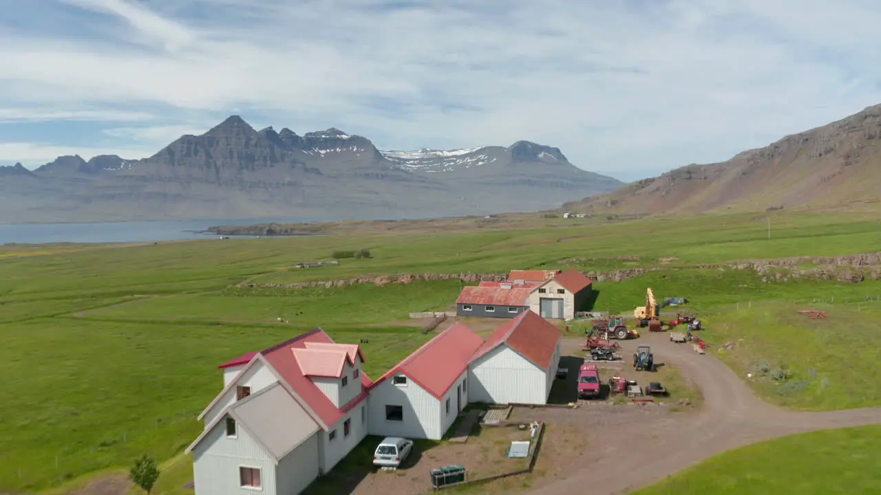 Aerial view of isolated country house in Icelandic countryside Drone view of snow mountain on Iceland coastline Nature landscape Beauty on earth