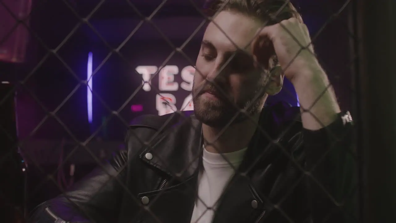 Portrait Of Sad Man Holding Beer Bottle While Sitting At Disco Club