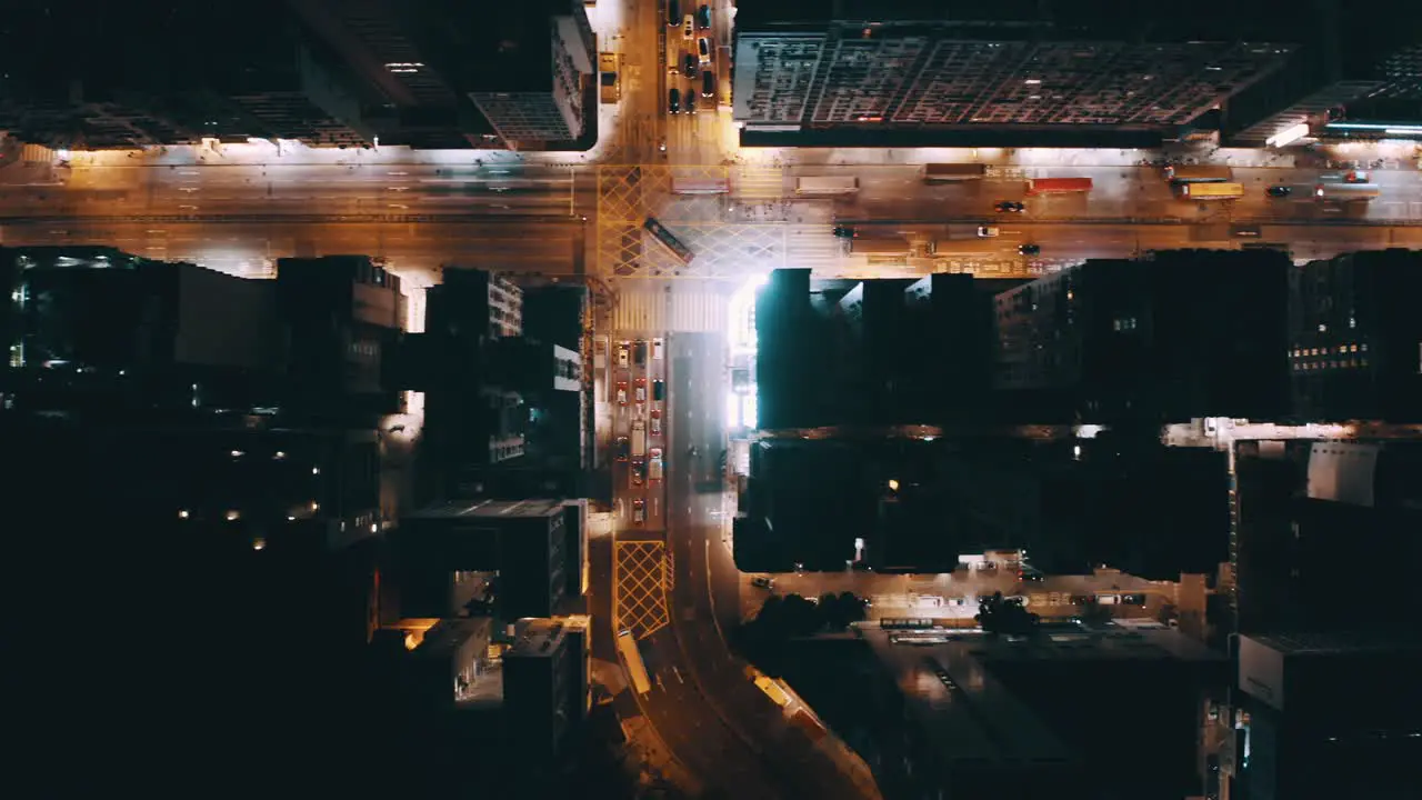 A top view of a street in a busy city during the night some bus and traffic stop at the traffic light