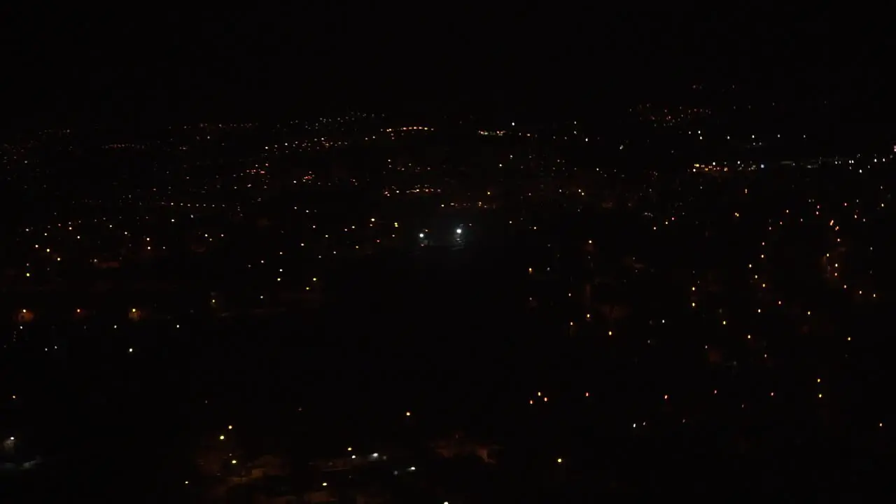 Lisbon at night seen from an airplane window while landing in slow motion