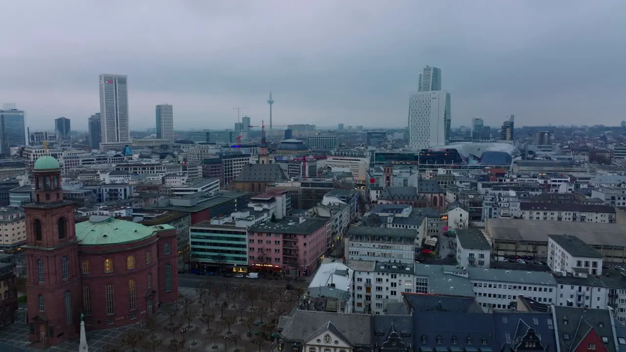 Forwards fly above old buildings and churches in city centre at dusk Modern buildings in background Frankfurt am Main Germany