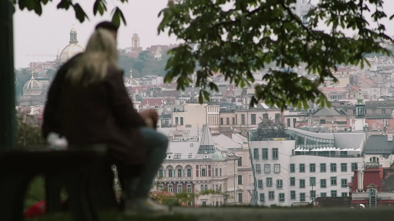 Young people on a park bench overlooking Prague