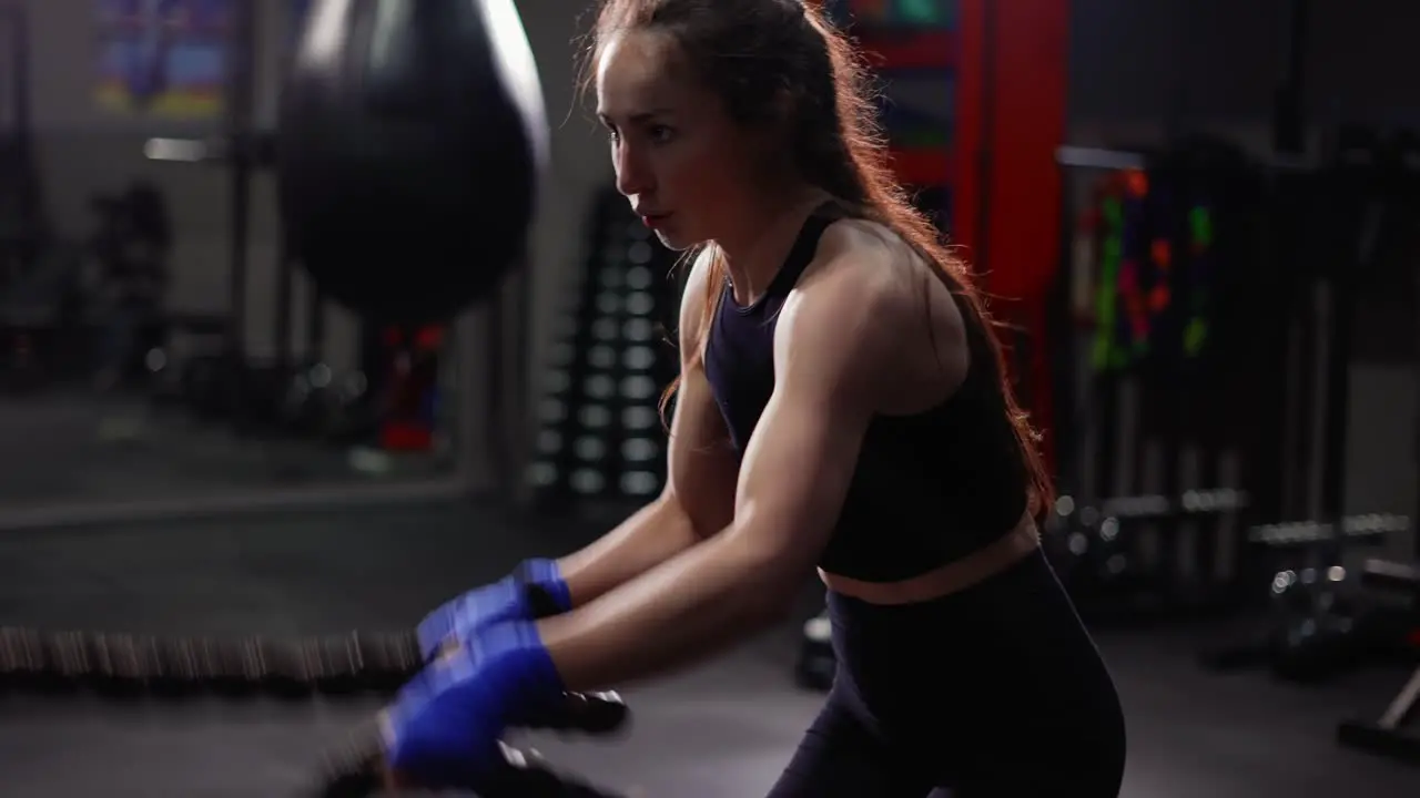 Female Boxer Doing Some Crossfit Exercises With A Rope Indoor Side View