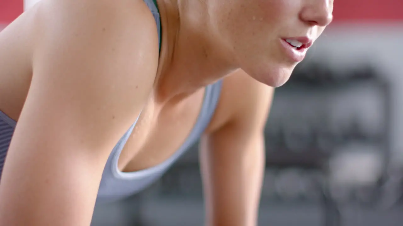 Fit focused young Caucasian woman exercising at the gym