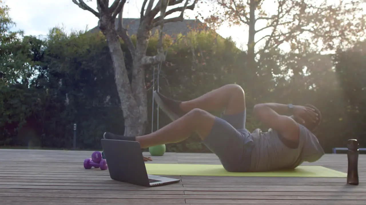 African American man exercises outdoors following an online workout