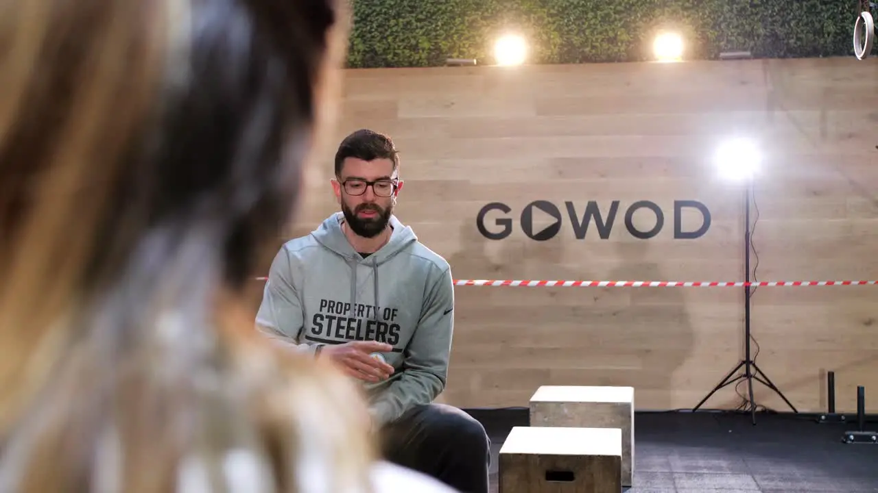 CrossFit Coaches Holding a Meeting in a Gym Prior to a Competition Bathed in Beautiful Lighting