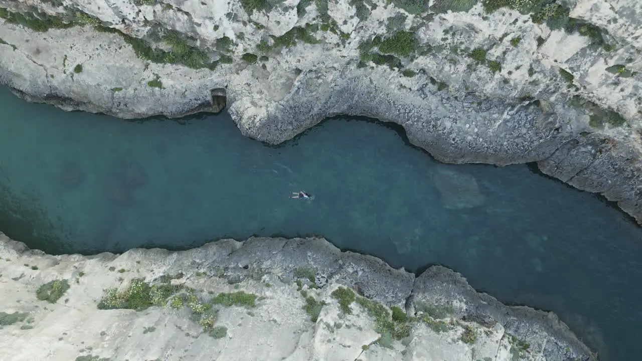 Aerial top down Footage of a swimmer in nature