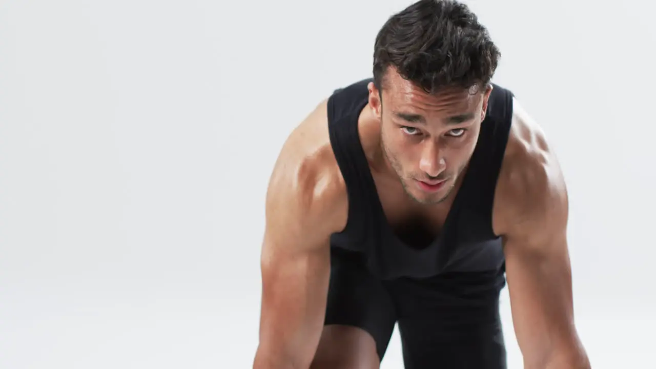 Focused young biracial man athlete in athletic wear ready for a workout on a white background