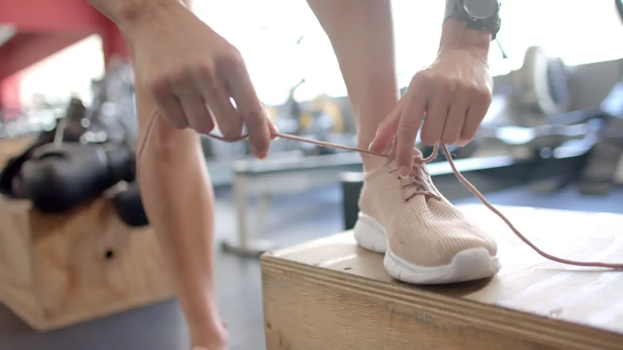 Athlete tying shoelaces at the gym with copy space