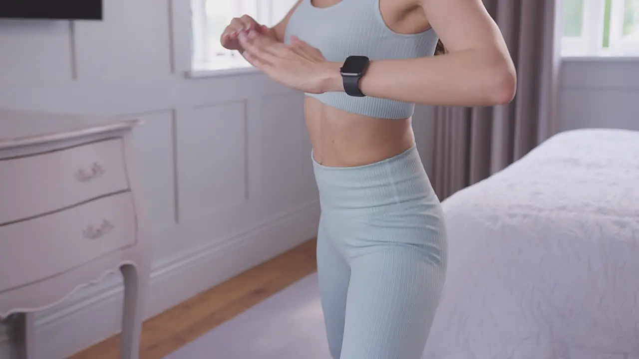 Woman doing yoga standing and stretching on exercise mat in bedroom at home shot in slow motion