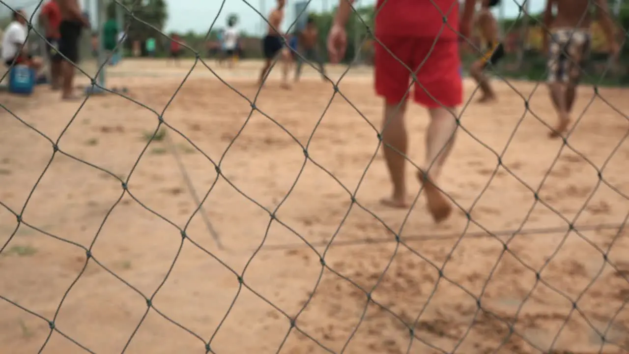 Close Shot People Playing Volleyball Behind a Chain Metal Fence