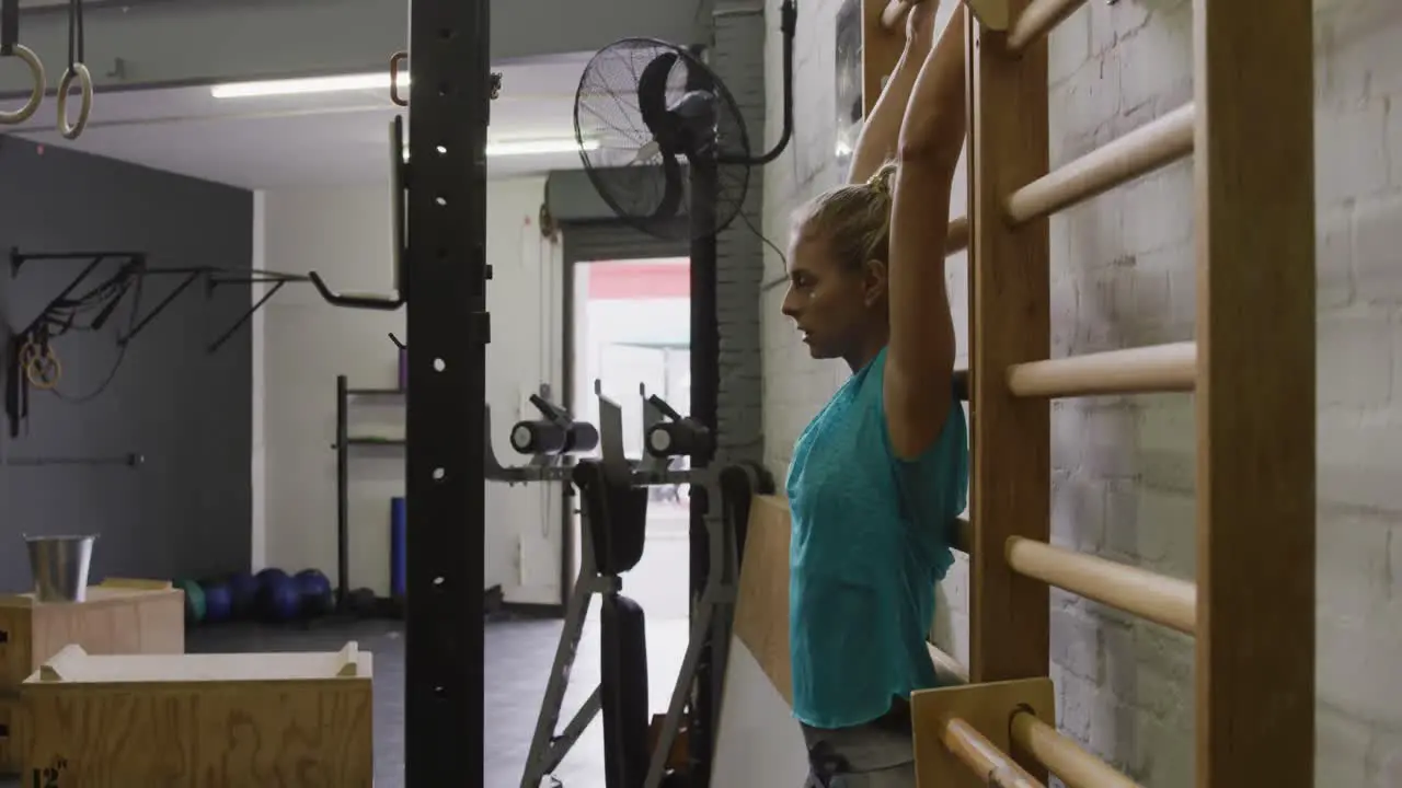 Side view of an athletic Caucasian woman doing leg lifts