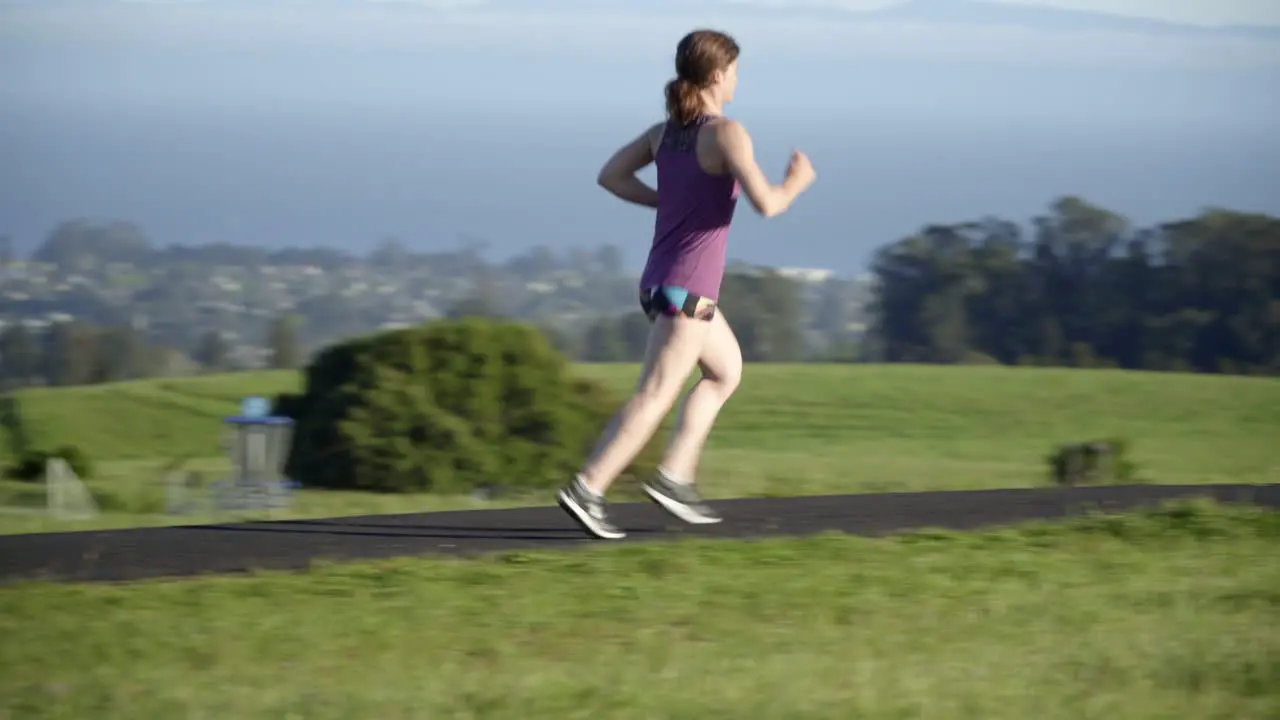 Young Woman Running on a Track at Sunset