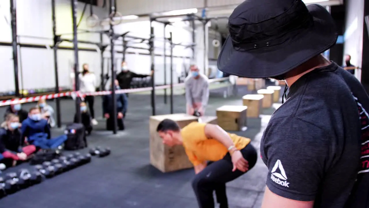 Athlete in crossfit gym working out jerk and clean exercise with dumbbell