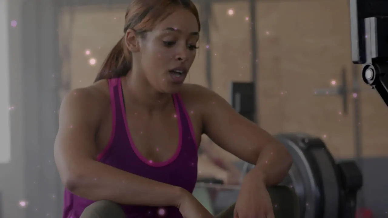 Animation of white spots over diverse women exercising at gym