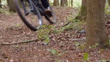 Close Up Of Man On Mountain Bike Cycling Along Trail Through Countryside And Woodland