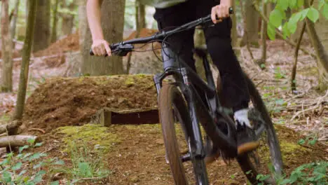 Slow Motion Shot Of Man On Mountain Bike Making Mid Air Jump On Dirt Trail Through Woodland 15