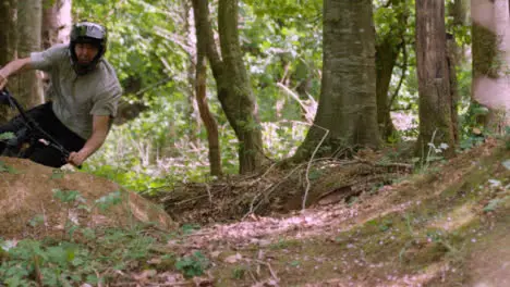 Close Up Slow Motion Shot Man On Mountain Bike Cycling Along Trail Through Woodland 