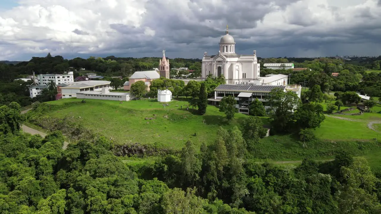 Aerial shot aproaching country churches under imminent storm in South Brazil