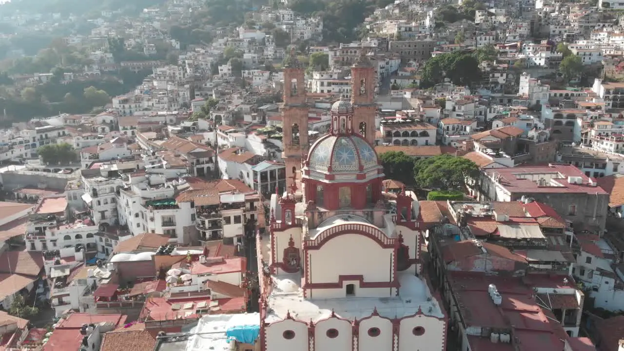 Back aerial view of the Catedral of Tasco in Mexico showing the beautiful design of its dome and the size of the building caompare to the surrounding house´s