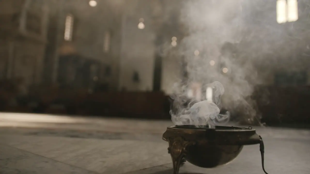 Footage of a bowl of incense on the floor of a church smoking in Bari Italy